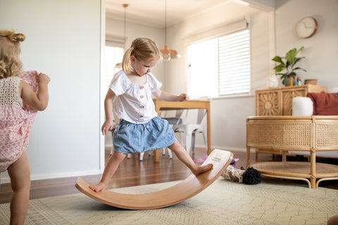 A little girl playing on her Wobbel  balance board.