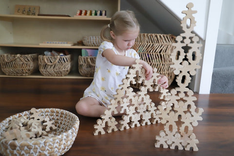 Little girl playing with Flockmen wooden toys