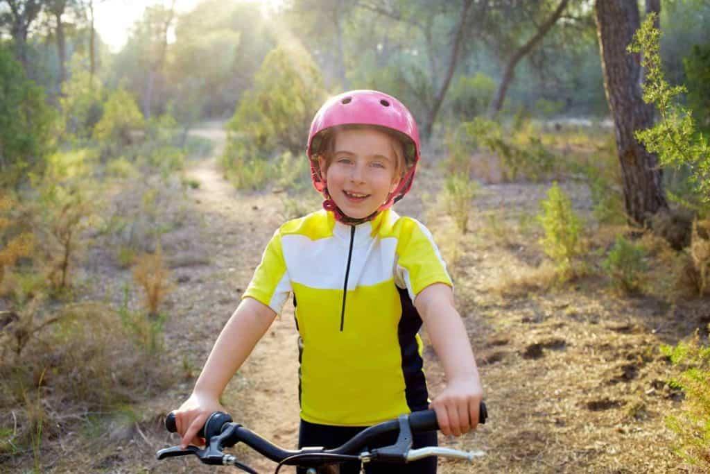 A child wearing a helmet and riding a bike
Description automatically generated with low confidence