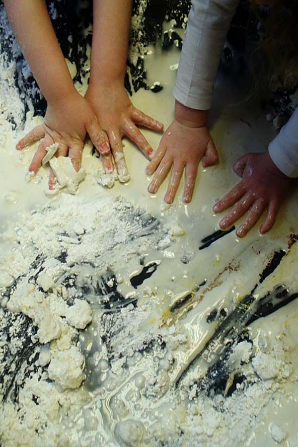 Children engage in enveloping schema play by covering objects in goop