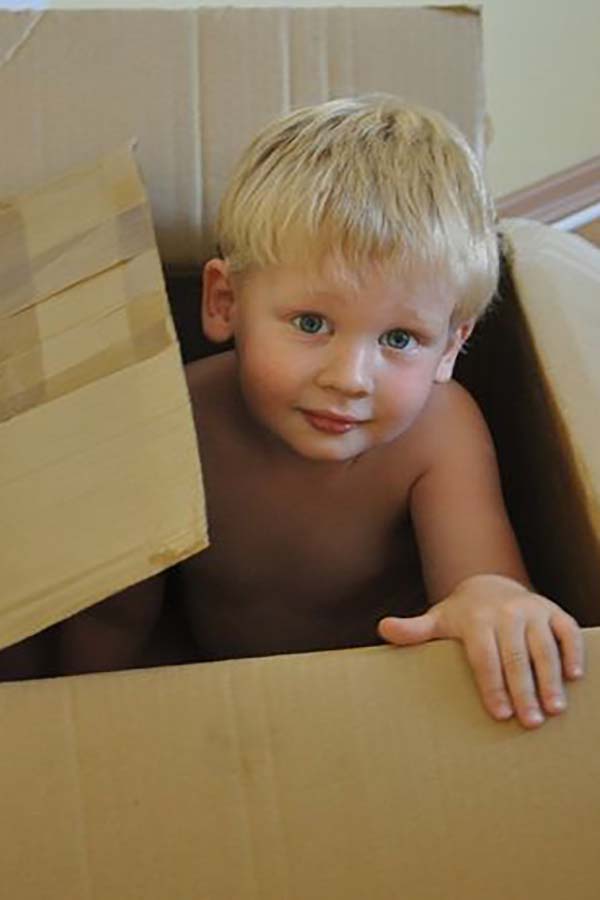 A boy hiding in a cardboard box is a good example of enveloping schema play