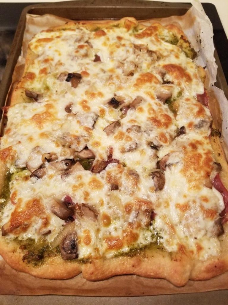Delicous Homemade Pizza with Prosciutto and Pesto for family pizza night. 