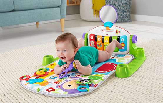 baby laying on the Deluxe Kick & Play Piano Gym