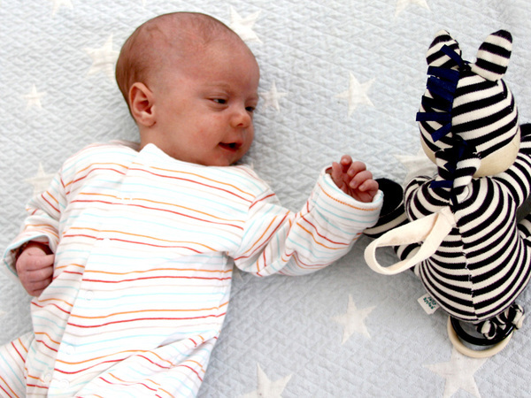 newborn reaching out for black and white toy