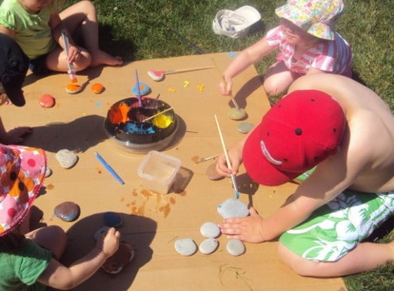 kids painting on stones in backyard