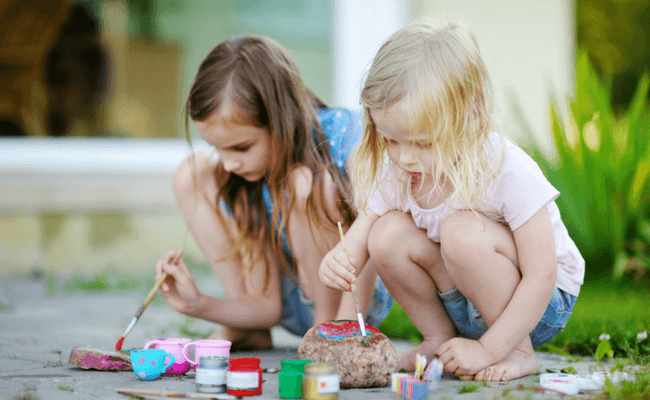 two children painting rocks