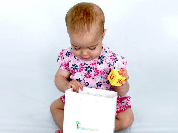 baby putting yellow block in a bag
