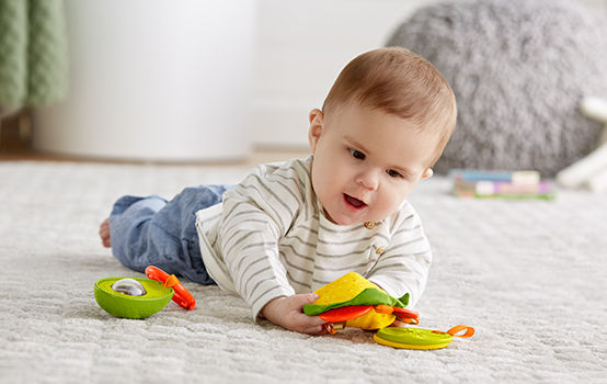 baby laying on floor with teether